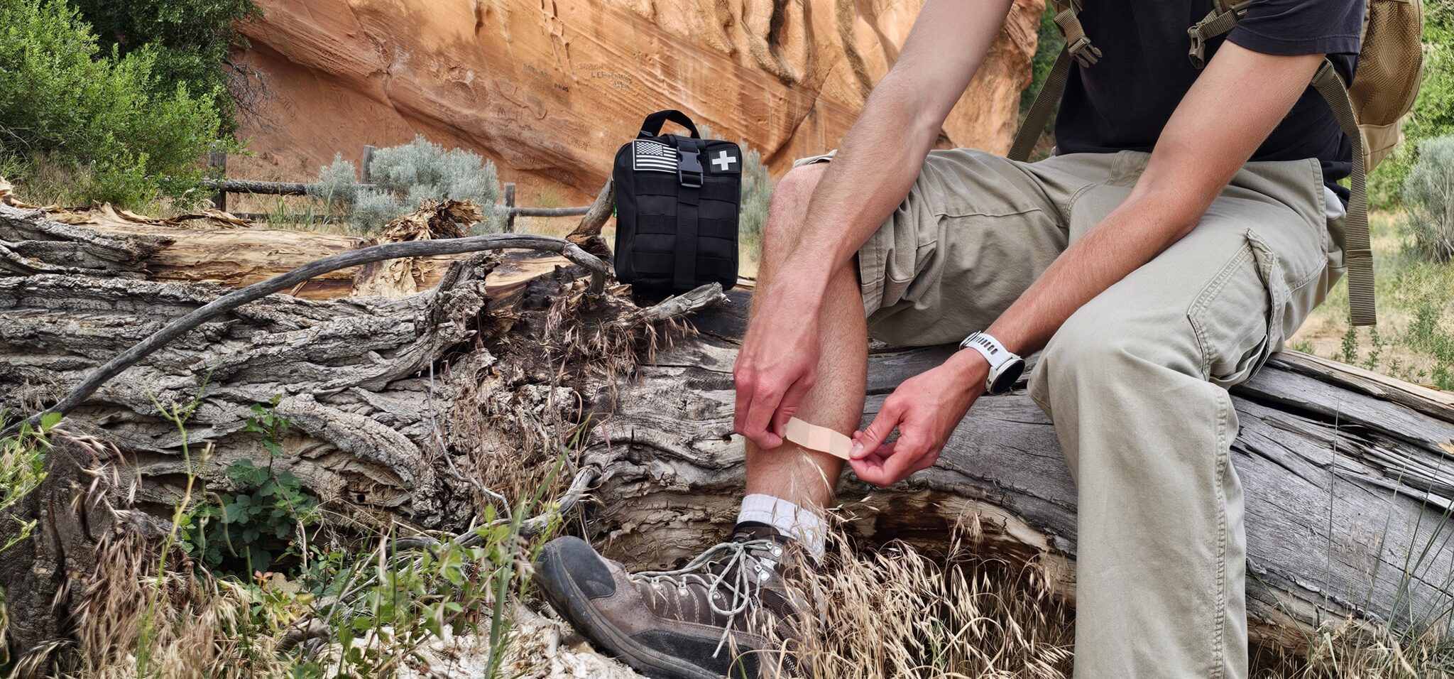Hiker applying bandage outdoors using Med Kit Pro first aid kit